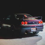 Bright sports auto on pavement in petrol station in twilight