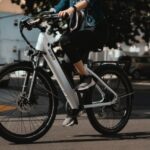 man in black jacket riding on white and black bicycle