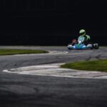person riding go kart racing on race track