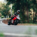 man in black helmet riding motorcycle on road during daytime