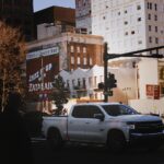 A white truck on a city street Description automatically generated