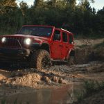 red suv on brown dirt road during daytime