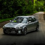A damaged silver car parked on a forest road in Belarus. Ideal for automotive and transportation themes.